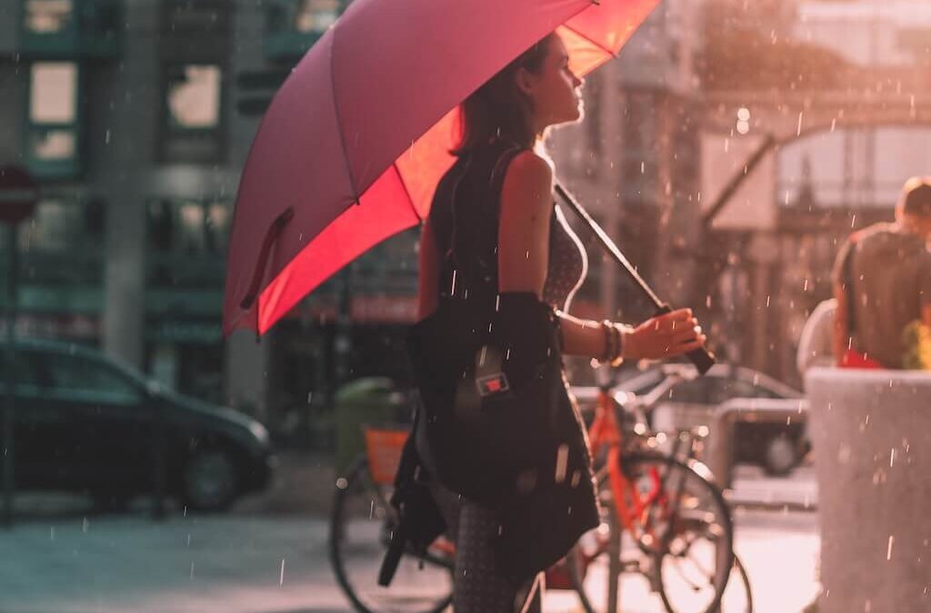 Femme sous son parapluie rouge, qui marche sous la pluie