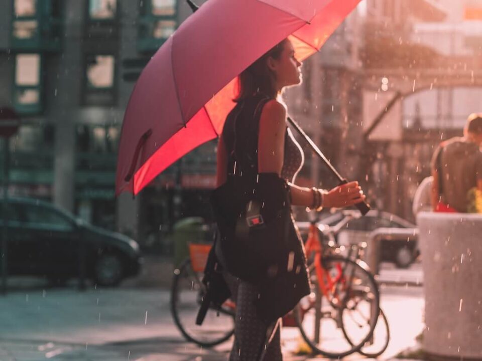 Femme sous son parapluie rouge, qui marche sous la pluie