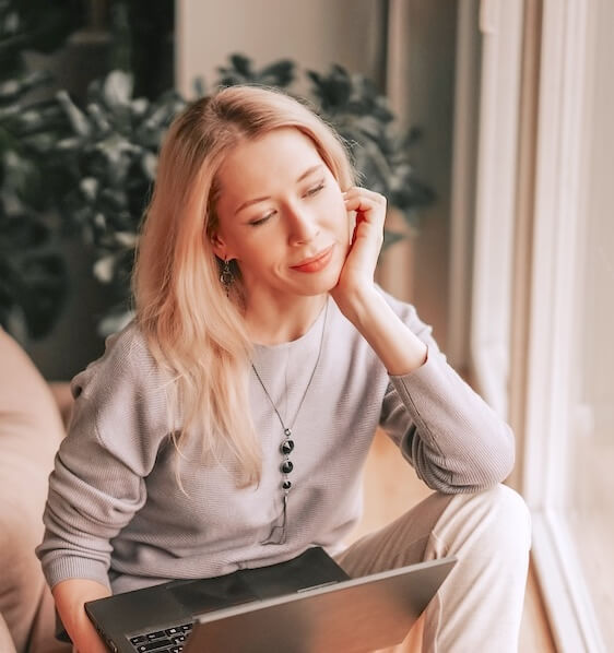 Jeune femme en train de réfléchir à ses ambitions et désirs professionnels. Elle semble sourire car elle a identifié une trajectoire qui lui correspond.