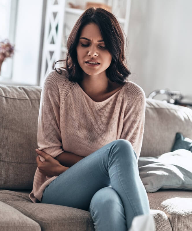 Femme qui semble se sentir mal ou avoir des douleurs comme mal au ventre.
