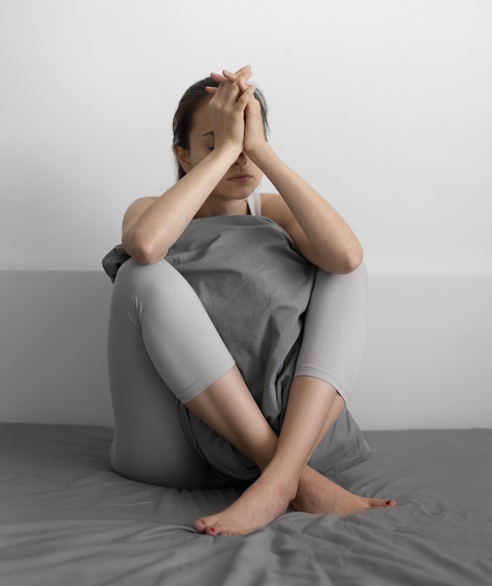 Jeune femme anxieuse, apeurée, angoissée qui se tient le visage.
