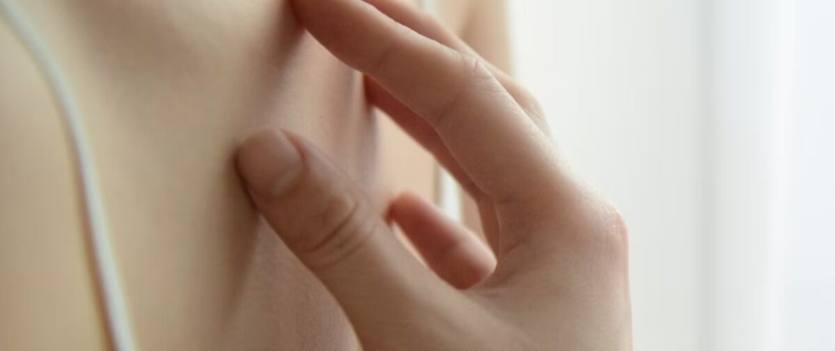 Main d'une femme qui gratte sa peau sur le haut de son buste