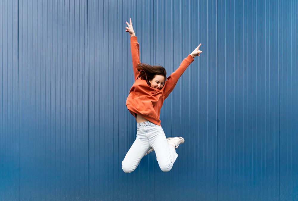 Femme dynamique et joyeuse qui saute bras en l'air