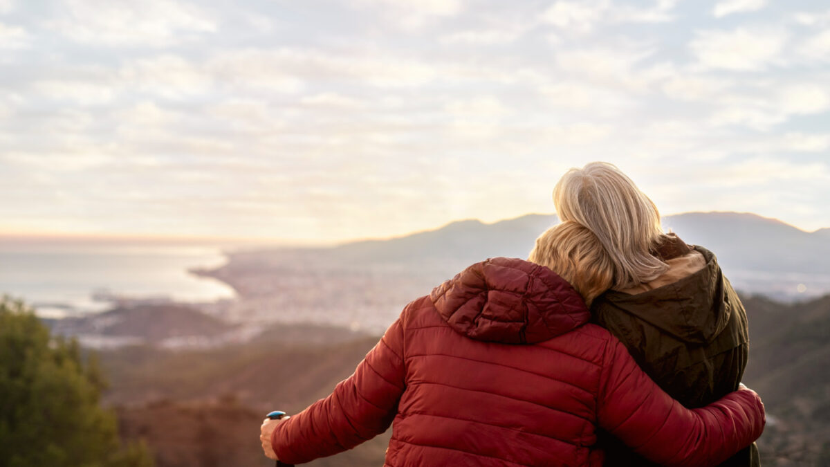 Paysage devant lequel une femme en soutient une autre