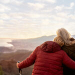 Paysage devant lequel une femme en soutient une autre
