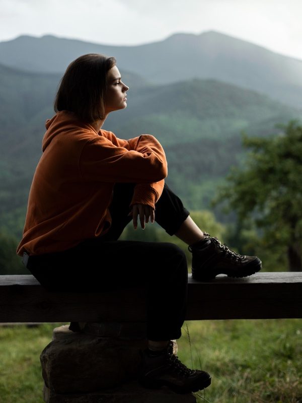 Femme dans la nature, qui semble anxieuse, pas sereine, ou qui n'a pas le moral