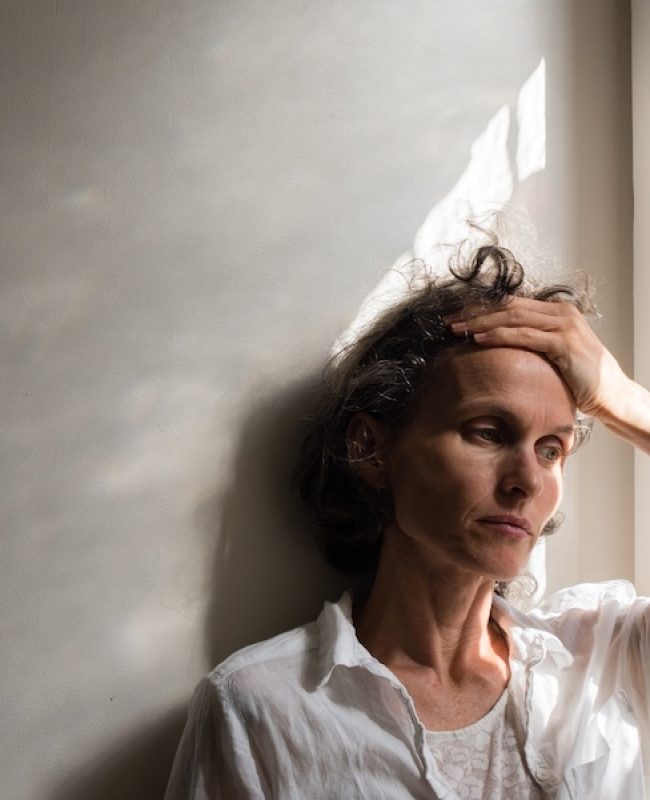 Femme qui se tient le front, stressée, surmenée