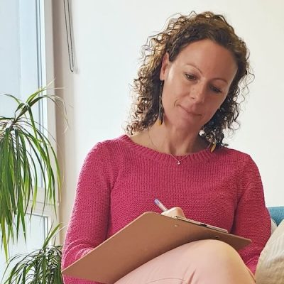 Charlotte Ingelbach naturopathe thérapeute énergéticienne qui prend des notes pendant une séance d'accompagnement de questionnement vers une transition professionnelle.